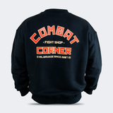 Back view of the Fire Fight Crew crewneck sweater by Combat Corner, featuring an arched orange and white graphic on the left chest that reads "Combat Fight Shop Corner" and a gold cuff tag.