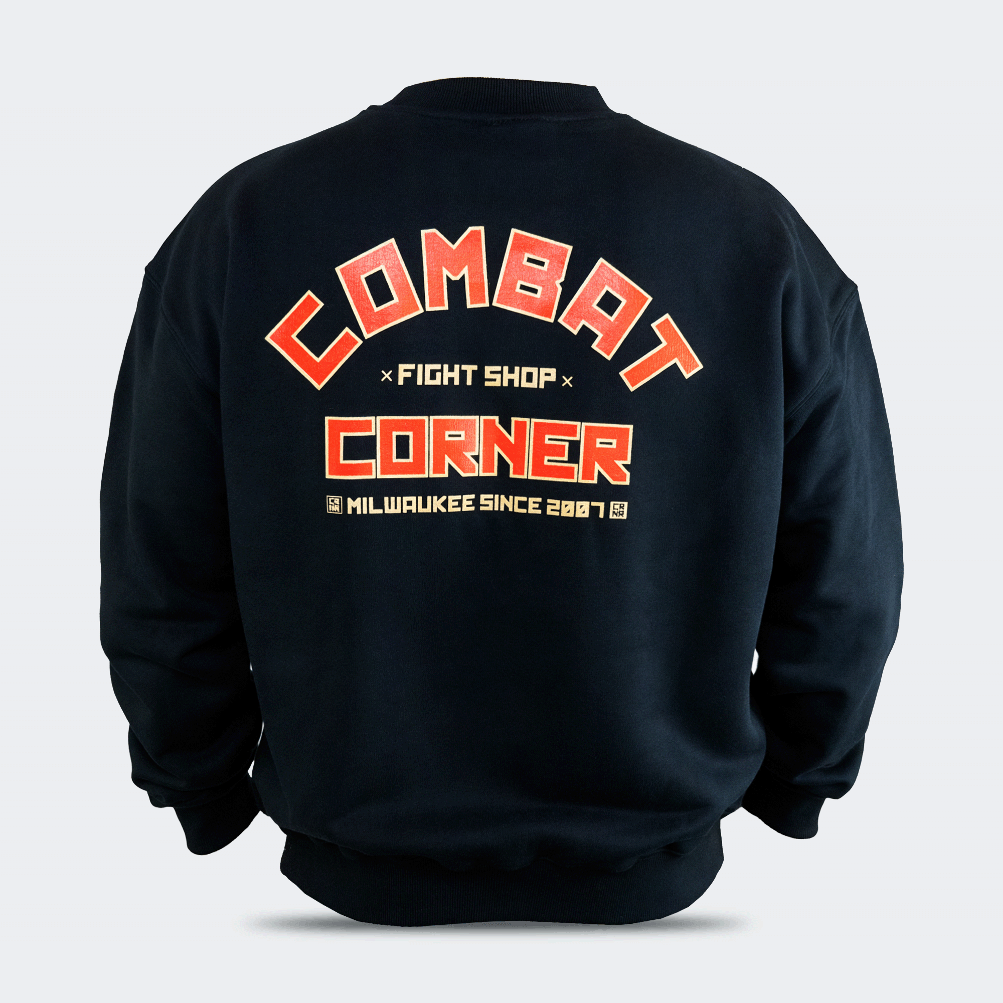 Back view of the Fire Fight Crew crewneck sweater by Combat Corner, featuring an arched orange and white graphic on the left chest that reads "Combat Fight Shop Corner" and a gold cuff tag.