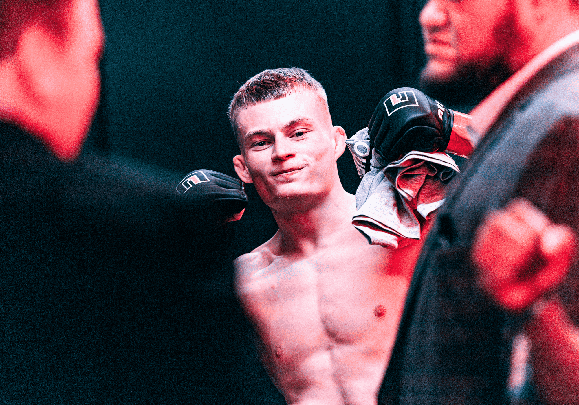 Combat Corner athlete Jeremy Stroble Jr. smiling and fist-bumping a cornerman while wearing black fight gloves before an MMA fight.