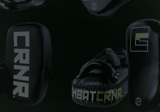 A product display of black combat sports gear from Combat Corner against a dark background, including belly pads, Thai pads, and punch mitts.