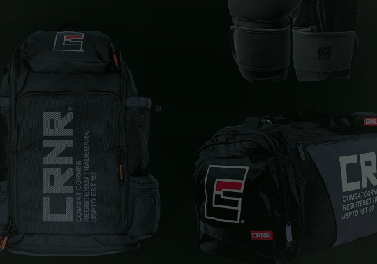 A product display of black combat sports gear from Combat Corner against a dark background, including gym bags, boxing gloves, and MMA gloves. 
