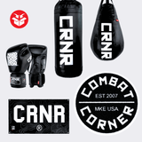 Photo example of the Combat Corner HWD Advanced Home Gym Bundle featuring HWD Boxing Gloves, CRNR Punching Bag, a CRNR banner, and a round Combat Corner area rug. 