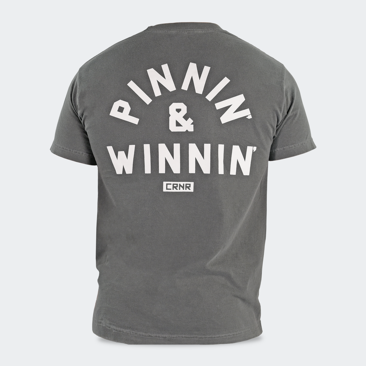 Product photo of Combat Corner’s exclusive Pinnin’ & Winnin’ Relaxed Tee. This photo shows the back of Combat Corner’s Pinnin’ & Winnin’ Faded Navy Relaxed Tee. This CRNR tee offers the same softness and comfort as your favorite, well-loved vintage tee.