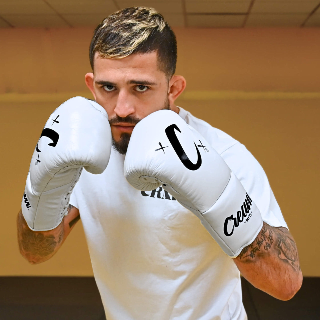 Photo of MMA champion Sergio Pettis training with Combat Corner's white Cream TM1 Competition Boxing Gloves, which are Japanese inspired Mexican Boxing Gloves that are hand made in Thailand.