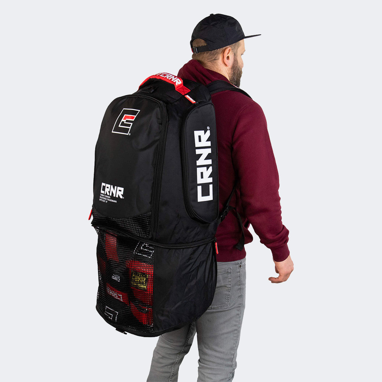 Product photo of an athlete wearing the Combat Corner Expand Pack Gear Bag showing the bag's expanding mesh section