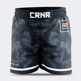 Straight-on front view of Combat Corner CRNR ISO black fight shorts. Features a wide, gathered elastic black waistband with a prominent white "CRNR" logo centered at the front. A square graphic logo with an orange accent bar is placed on the left thigh, and the small text "ISOSUTURE // HYBRID" is printed on the lower right leg hem.