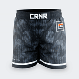Straight-on front view of Combat Corner CRNR ISO black fight shorts. Features a wide, gathered elastic black waistband with a prominent white "CRNR" logo centered at the front. A square graphic logo with an orange accent bar is placed on the left thigh, and the small text "ISOSUTURE // HYBRID" is printed on the lower right leg hem.
