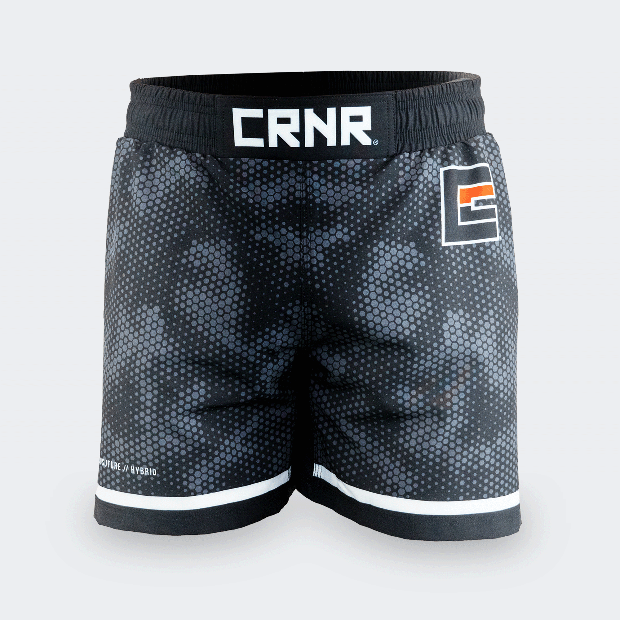 Straight-on front view of Combat Corner CRNR ISO black fight shorts. Features a wide, gathered elastic black waistband with a prominent white "CRNR" logo centered at the front. A square graphic logo with an orange accent bar is placed on the left thigh, and the small text "ISOSUTURE // HYBRID" is printed on the lower right leg hem.