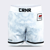 White Combat Corner hybrid fight shorts shown from the front against a light grey background. The shorts feature a white and grey hexagonal digital camouflage pattern, a wide white elastic waistband with a black "CRNR" logo patch centered, a black and red stylized "E" logo on the left thigh, and black trim along the bottom hems.