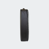 Side view of the HMITV Low Kick Pad Lite, a large, black leather martial arts low kick shield pad by Combat Corner against a light grey background, featuring a white block "CRNR" logo on the striking surface.