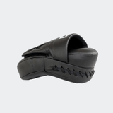 The left side view of the black HMITV Curved Punch Mitts by Combat Corner against a solid light grey background, showcasing the curved hand compartment and front striking surface.