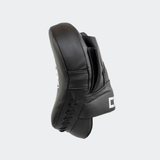 The right side view of the black HMITV Curved Punch Mitts by Combat Corner against a solid light grey background, showcasing the curved hand compartment and front striking surface.