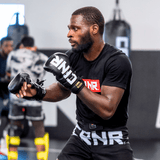 A photo of a left angle view of a pro fighter training with black Combat Corner HMIT Lace Up MMA Sparring Gloves during a sparring session. 