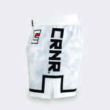 The left side view of the white CRNR ISO athletic fight shorts against a light gray background. The fabric showcases the white and gray hexagonal camo pattern. A large, bold black "CRNR" logo runs vertically down the side of the leg, framed at the bottom by a thick, angular black line that outlines the side hem slit. Towards the front hip area, a smaller square logo features a stylized black letter "E" with a red horizontal stripe inside.