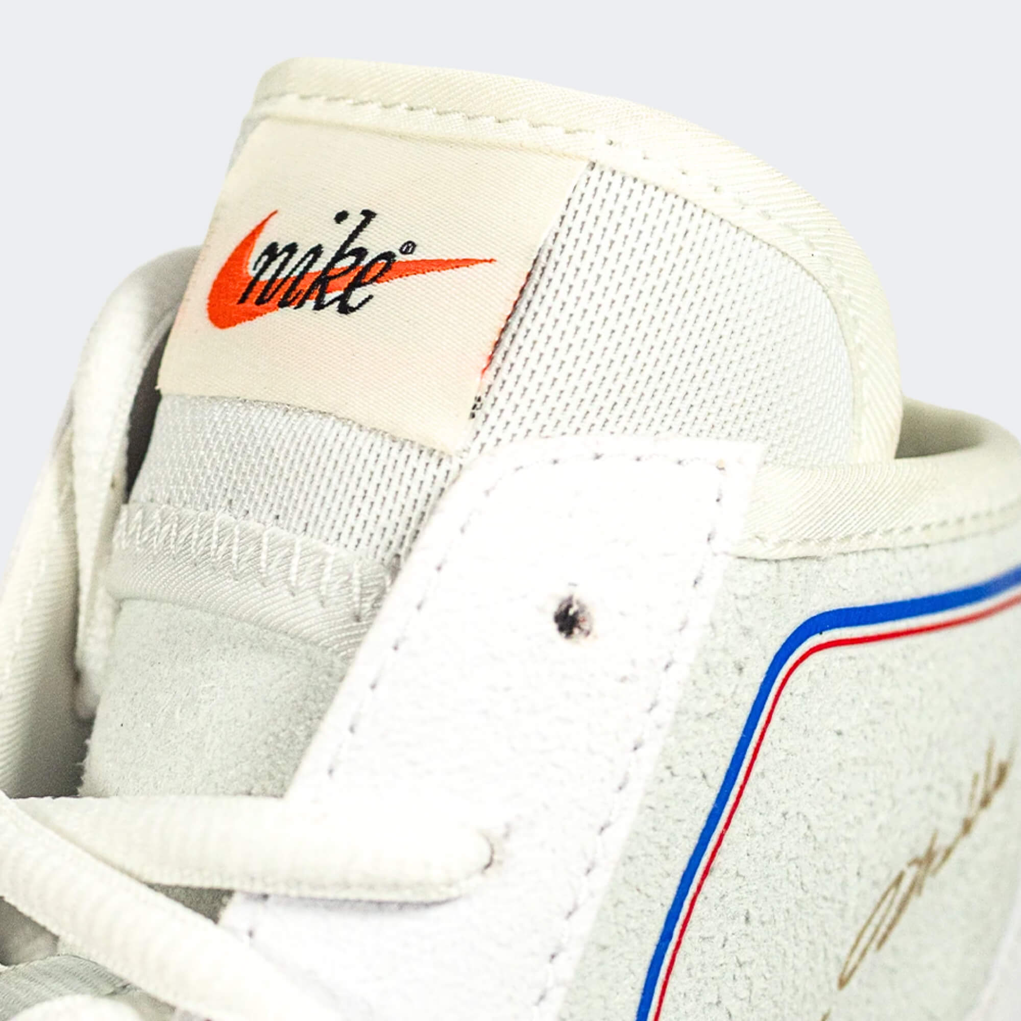 A close up detail photo of the classic Nike tag on the tongue of the Nike Footsweep 2 wrestling shoe in SE Photon, available from Combat Corner.