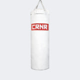 Photo of the front of Combat Corner's white with red label 100 lbs. Made in the USA Punching Bag.