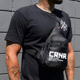 Photo of a man wearing the CRNR Sling Bag by Combat Corner on his way to his next training session