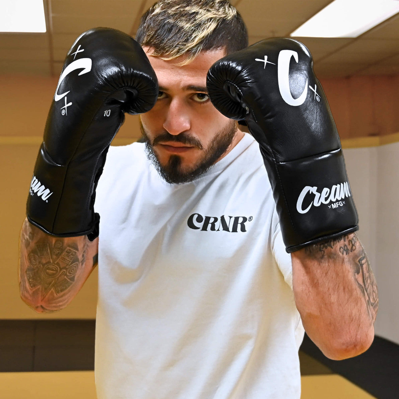Photo of MMA champion Sergio Pettis training with Combat Corner's black Cream TM1 Competition Boxing Gloves, which are Japanese inspired Mexican Boxing Gloves that are hand made in Thailand.