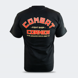 A black Combat Corner T-shirt shown from the back against a light gray background. The shirt features bold text graphic in red, orange, and gold. The word "COMBAT" is arched across the top in large, blocky red letters with a gold border. Below it, the words "FIGHT SHOP" are written in a smaller gold font, flanked by two small "x" marks. Underneath that, the word "CORNER" is printed in large, rectangular red block letters with a gold outline. At the bottom, a smaller line of text reads "MILWAUKEE SINCE 2007"