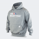 Three-quarters angled view of the gray Combat Corner USA Muay Thai lifestyle hoodie, displaying its heavy-weight fabric construction, relaxed fit, ribbed cuffs, and front graphics.