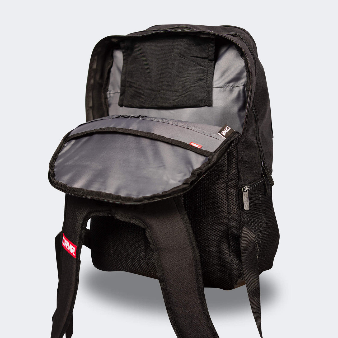 Product photo of the front right angle of the black Combat Corner Vital 30 Training Backpack showing the bag's open storage compartments and pockets